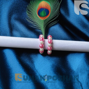 Pink and white bead kadha for Laddu Gopal Ji displayed on a white roll with a blue satin background and peacock feather – devotional jewelry from sumanposhak.com.